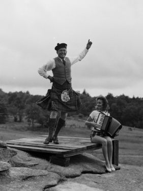 "Donald MacDonald dancing the Highland Fling while girl plays accordion at first Highland Games in 1956 near Grandfather Mountain, NC." Photographed by Hugh Morton. Image courtesy of UNC- Chapel Hill Libraries. "Donald MacDonald dancing the Highland Fling while girl plays accordion at first Highland Games in 1956 near Grandfather Mountain, NC." Photographed by Hugh Morton. Image courtesy of UNC- Chapel Hill Libraries.
