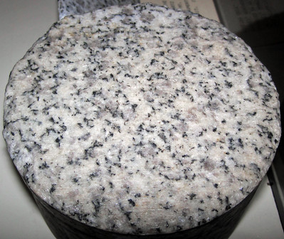 Una piedra redonda, blanca con manchas negras y grises por todas partes.