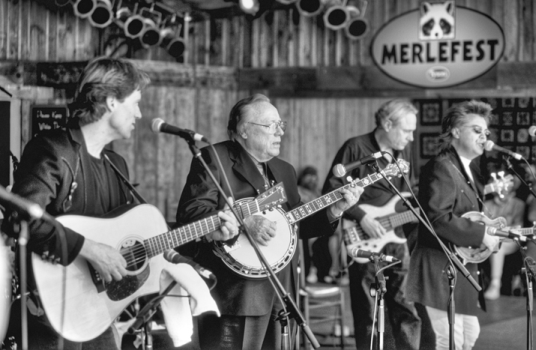 A performance at MerleFest in Wilkesboro, 29 Apr. 2001. Left to right: Brad Davis (guitar), Earl Scruggs (banjo), Gary Scruggs (bass guitar), and Marty Stuart (mandolin). Photograph by David Schenk.