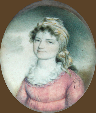 George Edmund Badger's mother, Lydia Cogdell Badger. She is wearing a pink dress and tan hair wrap. She is smiling. 