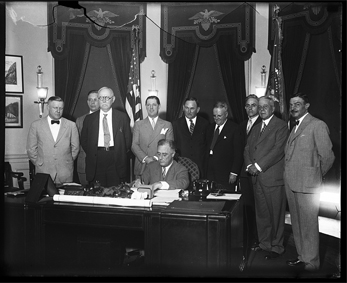 Photograph of President Franklin Roosevelt (FDR) signing the Small Home Loan Measure, 1933, by Harris & Ewing.  From the Harris & Ewing Collection, Library of Congress Prints & Photographs Online Catalog. William F. Stevenson, Chairman of the Home Loan Bank Board, is listed among those seen in the photograph. 