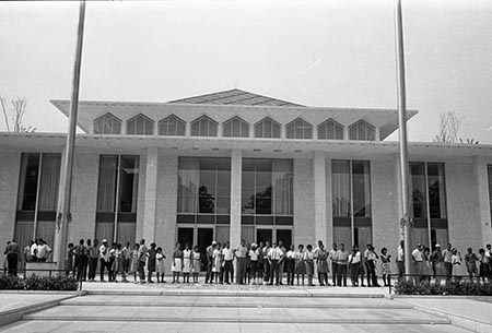 Black protestors gather outside a large legislative building.