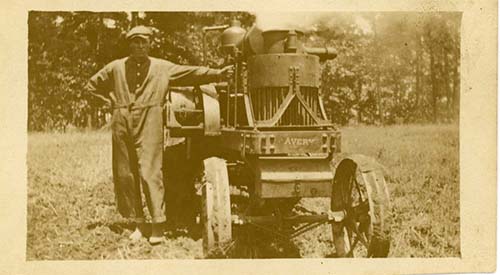 Photograph of a farmer standing next to his 1917 Avery 8-16 tractor. The tractor ran on gas or kerosene. The Arndt family farm was located in Catawba County, N.C. Photograph from the collection of the Historical Association of Catawba County, DigitalNC.