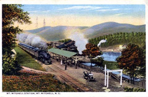 Postcard image of the Mt. Mitchell Station at Mt. Mitchell in North Carolina. Image ca. 1918.  Developed from the existing logging trains, the tourist railroad became one of the earliest and most popular tourist attractions in the state when it opened in 1915. During its four years of operation, more than 10,000 tourists were transported to Camp Alice which sits just below the summit of the mountain. There they could dine, camp and enjoy a short mile hike to the summit. The train and logging operations ceased by 1921 when the mountain slope forests had been depleted. Image from NC Postcards, UNC-Chapel Hill. 