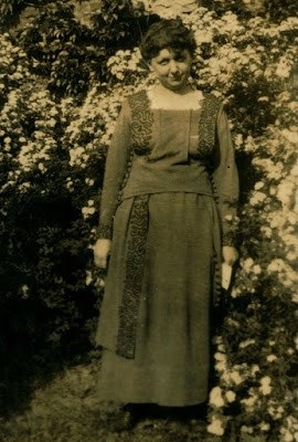 Photograph of Harriet Elliott standing in front of floral bushes, courtesy of University of North Carolina at Greensboro Special Collections and University Archives.