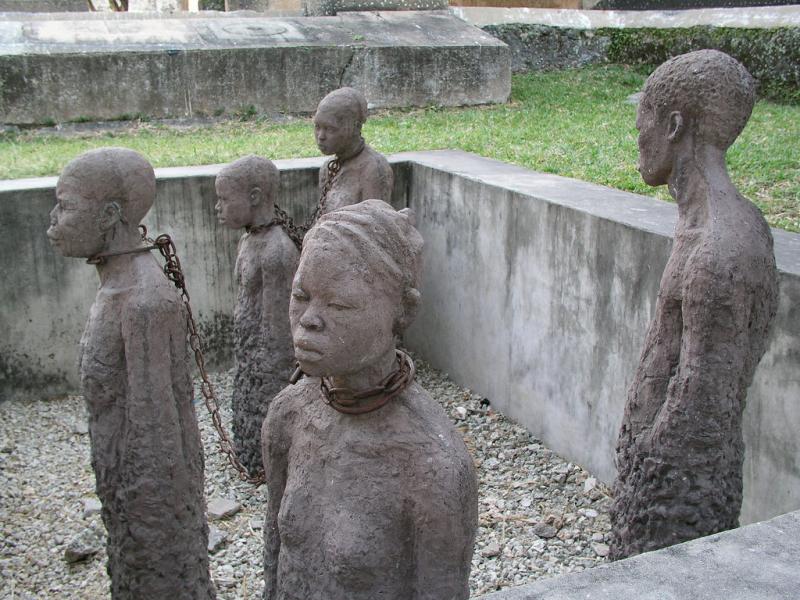Slave trade memorial at Zanzibar Slave trade memorial at Zanzibar. 5 states of enslaved people stand in a square. They are thin and their clothes are ragged.