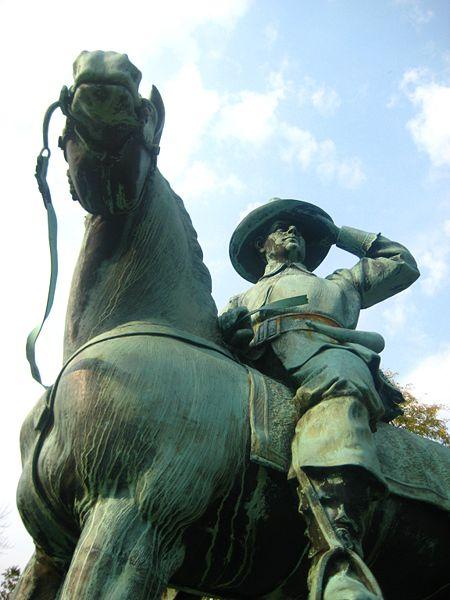 Statue of a man in uniform sitting on a horse.