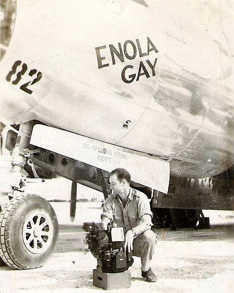 A pilot sits beside an aircraft labeled "Enola Gay."