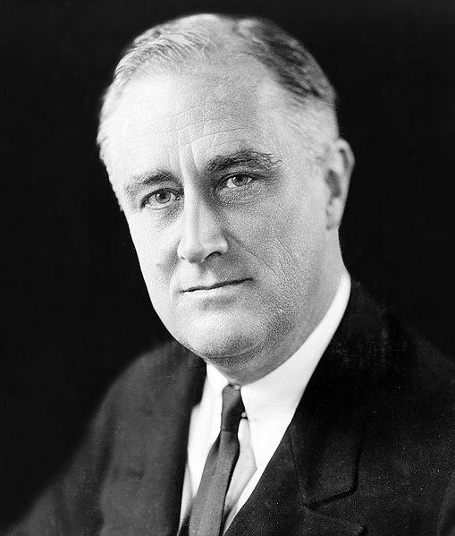Franklin Delano Roosevelt. He is serious. He has short hair and a suit.