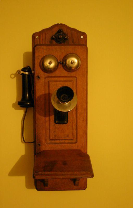 A wooden wall mounted telephone. 