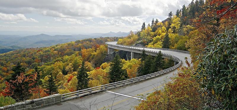 Large viaduct spanning a mountainside. Trees are a wide array of colors.