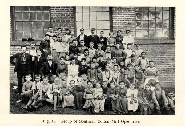 A group of women, children and men standing in front of the Cotton Mill building