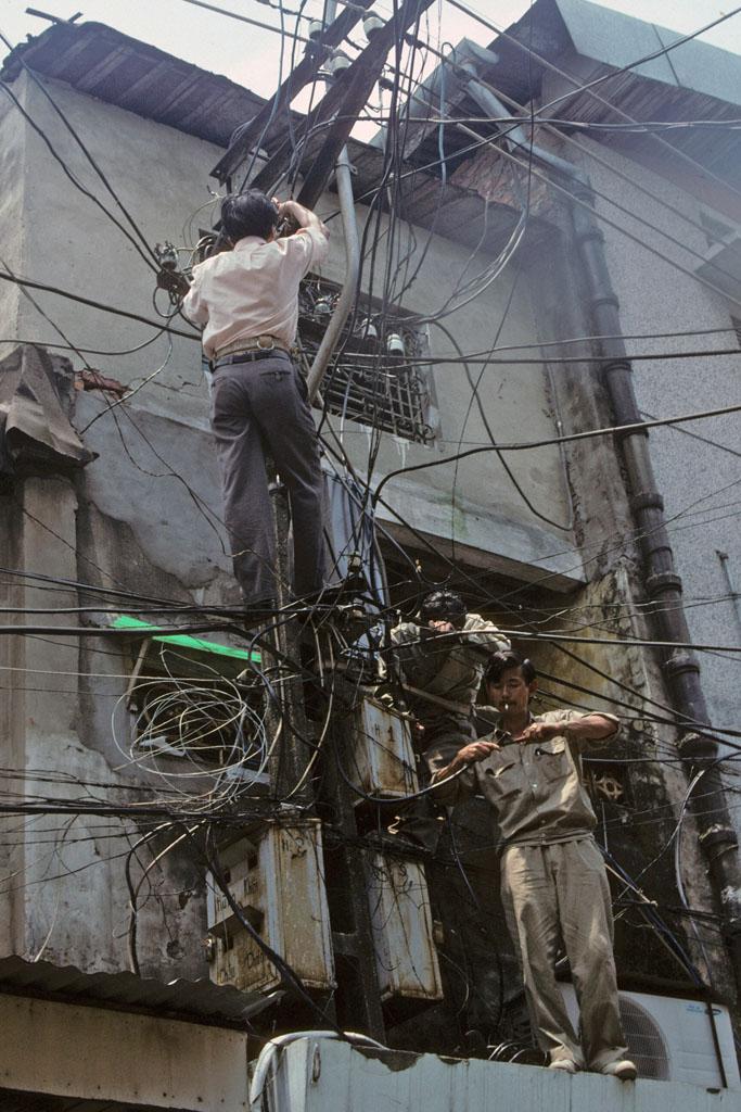 <img typeof="foaf:Image" src="http://statelibrarync.org/learnnc/sites/default/files/images/vietnam_146.jpg" width="683" height="1024" alt="Two electricians climb, Hanoi" title="Two electricians climb, Hanoi" />