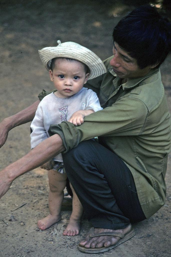 <img typeof="foaf:Image" src="http://statelibrarync.org/learnnc/sites/default/files/images/vietnam_237.jpg" width="683" height="1024" alt="Toddler standing between knees of man caring for her at Mai Chau" title="Toddler standing between knees of man caring for her at Mai Chau" />