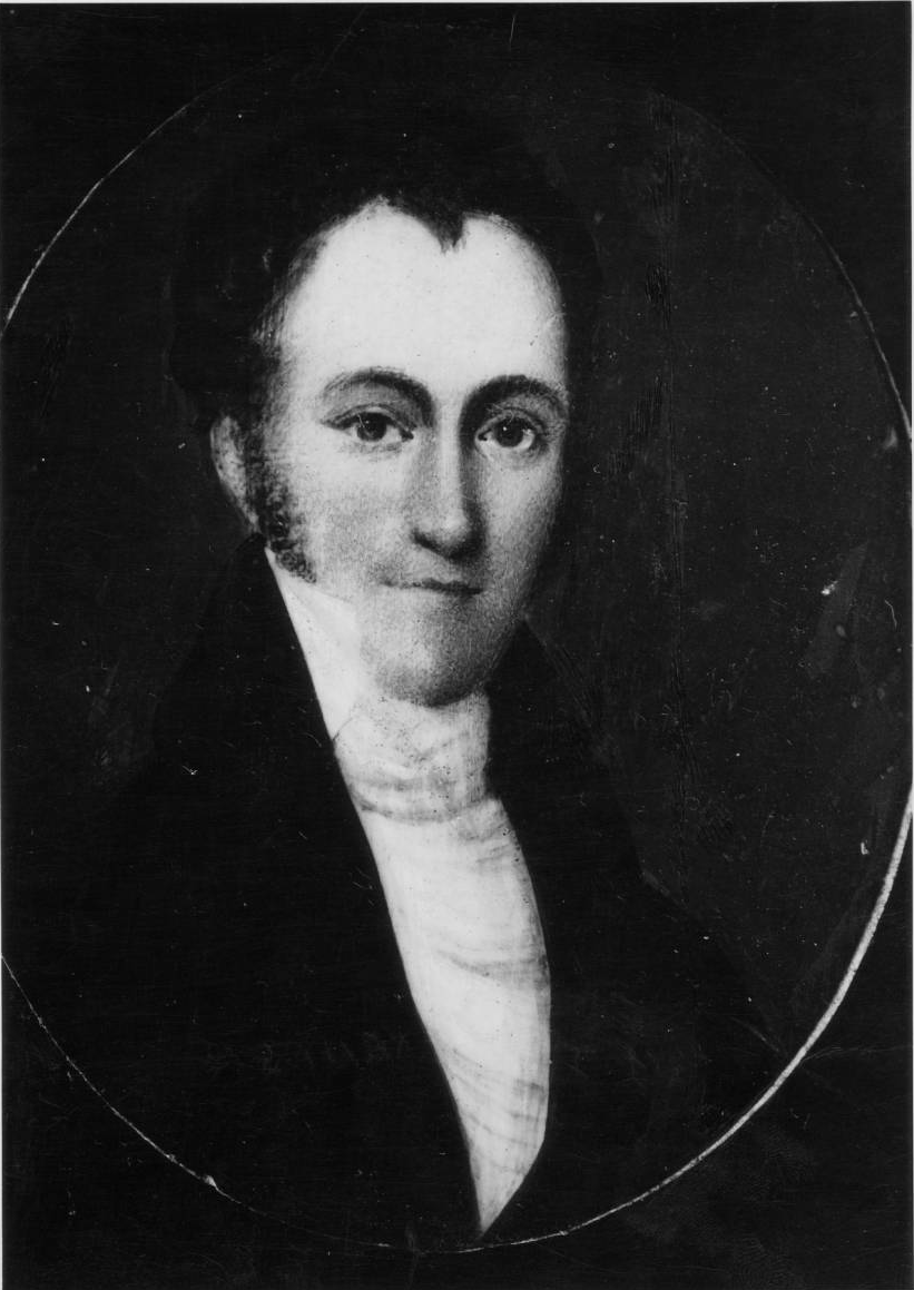 William Julius Alexander. He is depicted wearing a coat and high collared shirt. He has medium hair with a harsh widow's peak. He is smirking. 