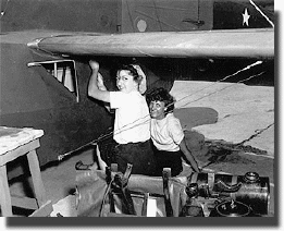   Female workers repair a plane at Morris Field during WWII. The workers have been identified as Dot Cathey (Horne) (left) and Jo Allred (right). Image from the Carolinas Historic Aviation Commission / Charlotte-Mecklenburg Historic Landmarks Commission.