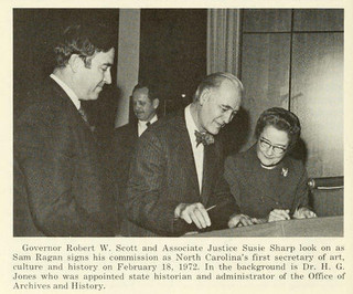 Governor Robert W. Scott, Associate Justice Susie Sharp, and Sam Ragan signing his commission as first Secretary of Art. Image from the Government & Heritage Library, State Library of N.C.