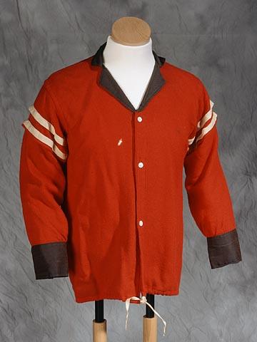 A Red Shirt uniform. It is a red button up shirt with white stripes on the sleeves and a brown collar. 