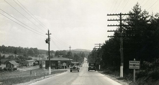 Road lined with electric and telephone poles, 1910-1920.