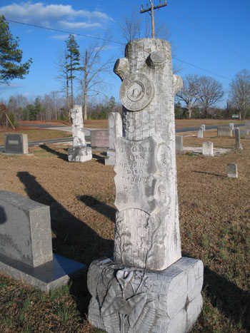 Log-shaped gravestone for a member of the Woodmen of the World, Wahaw, N.C. Image from Flickr user catchesthelight (BEV Norton).