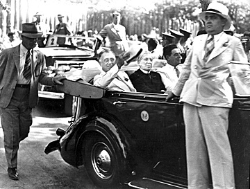 (L-R) President Franklin D. Roosevelt riding in open car with Governor Clyde Hoey and Congressman Lindsay C. Warren at the entrance to rebuilt Fort Raleigh, Manteo, NC, on or just before August 18, 1937, when he came to see the Lost Colony. From the State Archives of North Carolina, call #: ConDev57-314.