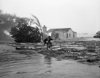 "Julian Scheer wading through debris after Hurrican Hazel (1954), Carolina Beach, NC." Image courtesy of UNC Libraries.