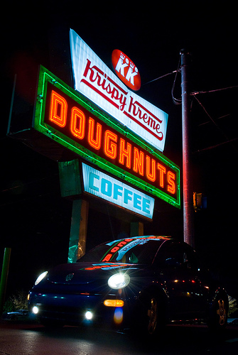 Krispy Kreme neon sign. It is large and promotes doughnuts and coffee.