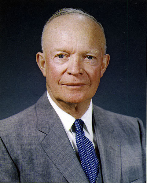 Dwight D. Eisenhower portrait. He is balding, and smiling. He is wearing a suit.