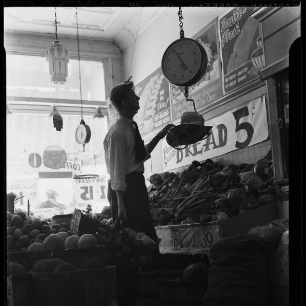 Man weighing produce in grocery store.