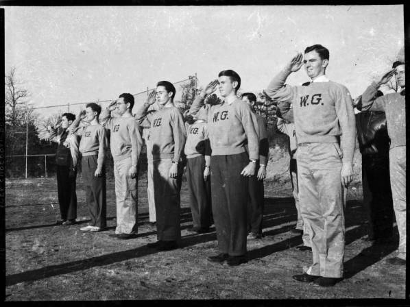 Black and white photo of men saluting. They are fit and have short hair.