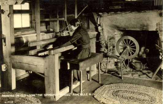 A woman weaves on a wooden loom.