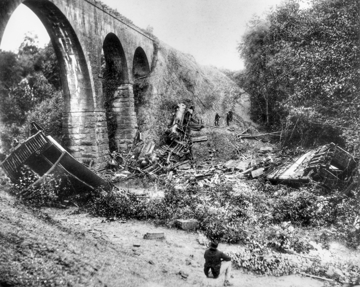 The locomotive and remains of wooden passenger cars at the base of the 60-foot-high Bostian Bridge over Third Creek near Statesville. Photograph by William Stimson, courtesy of Betty Boyd. North Carolina Collection, University of North Carolina at Chapel Hill Library.