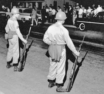 Photograph, National Guardsmen face off with townspeople in Henderson after being mobilized by Governor Luther Hodges during the Harriet-Henderson Mills strike in May 1959. Courtesy of North Carolina Office of Archives and History, Raleigh. The Raleigh News and Observer files.