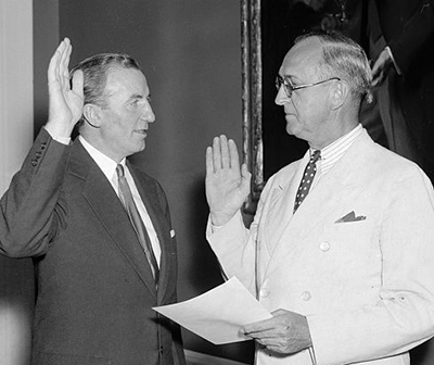 Harris & Ewing. "Hanes [left] takes oath as Assistant Secretary of Treasury. Washington, D.C., July 1. John W. Hanes, former New York broker and member of the S.E.C., pictured taking the oath of office today as Assistant Secretary of The Treasury from Frank Birgfeld, Chief Clerk ...". Photograph. July 1, 1938. LC-H22-D- 4206. Prints and Photographs Division, Library of Congress.