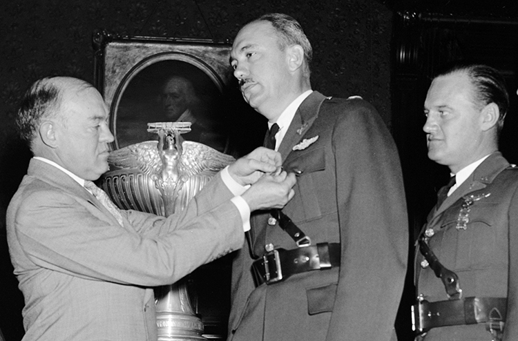 War Secretary Harry H. Woodring (left) pins medals on Carl J. Crane (center) and George V. Holloman (right). Harris & Ewing. "War Secretary presents Army Flyers with Mackay Trophy. Washington, D.C., Oct. 14. As a reward for their development and demonstration of the original automatic landing device for aircraft, Captains Carl J. Crane and George V. Holloman, U.S. Army Air Corps, were today presented with the MacKay trophy for 1937 by Secretary of War Harry H. Woodring. Gold medals, emblematic of the trophy were presented the Flyers at the same time. Left to right: Charles F. Horner, Chairman of the National Aeronautic Association; Secretary Woodring, Capt. Carl J. Crane, and Capt. George V. Holloman, 10/14/38". Photograph. [19]38 October 14. LC-H22-D- 4701. Prints and Photographs Division, Library of Congress.