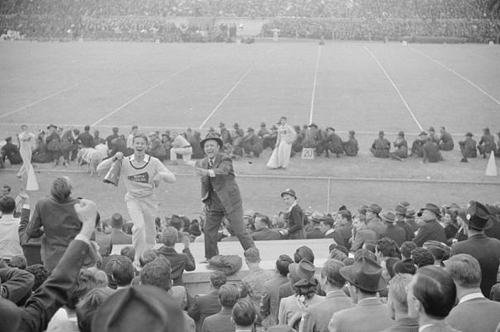   Kay Kyser and cheerleader cheering for North Carolina team at Duke University-North Carolina football game. Durham, North Carolina. Courtesy of the Library of Congress. 