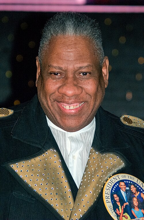 Talley smiling. He has gray short hair, and he is wearing a suit with a decorative collar. He wears a large button on his coat that depicts the Obama presidential family.