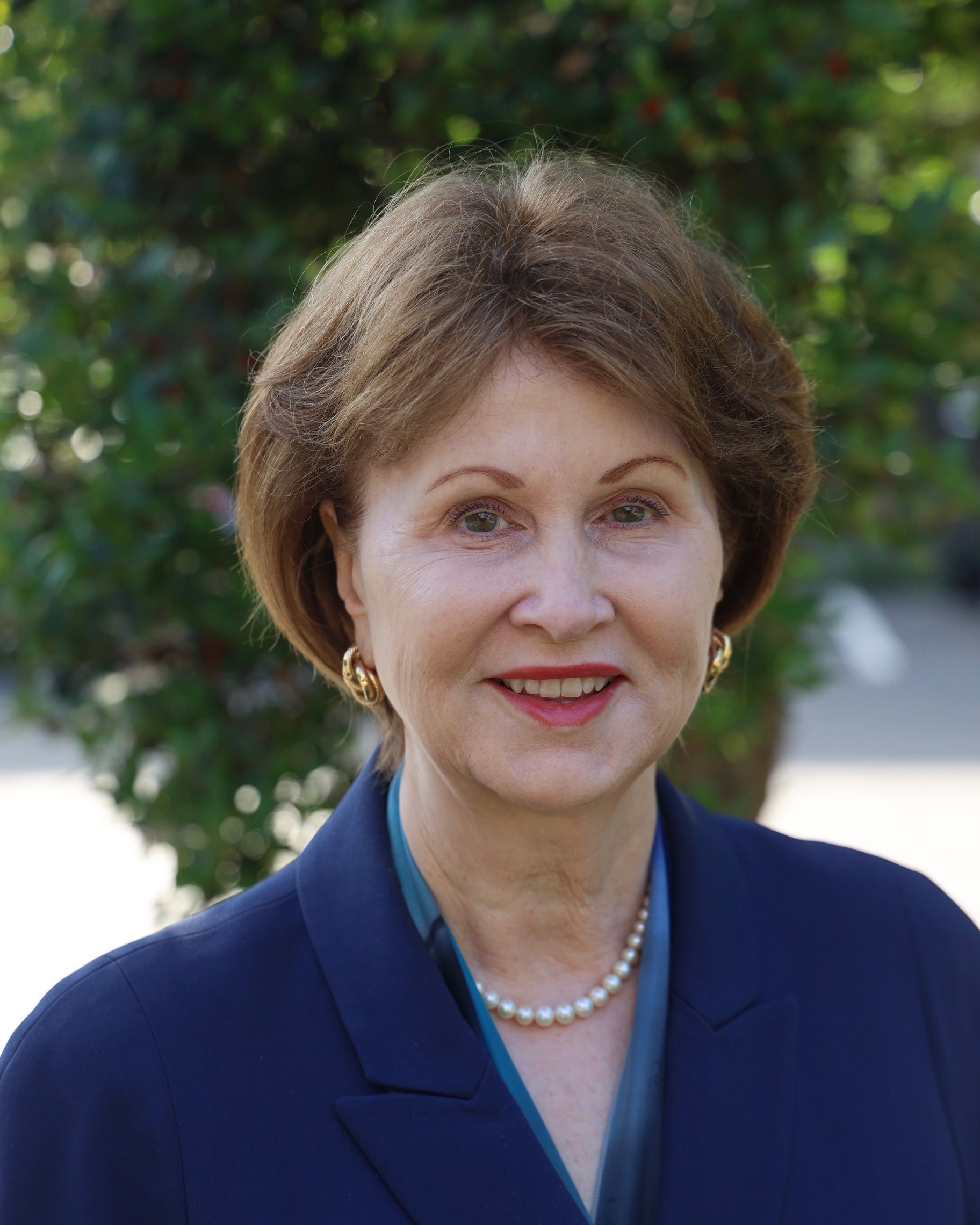Hope Williams smiling. She is wearing a blue suit and has a styled short haircut.