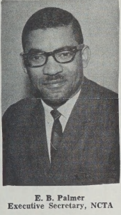 E.B. Palmer. He is photographed wearing a suit, tie, and glasses. He is smiling, and is about 36 here. 