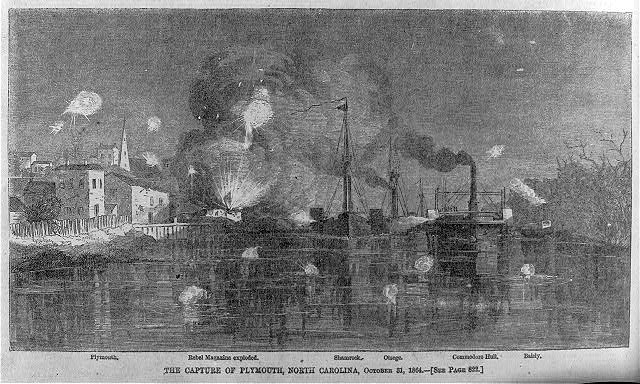Print depicting the capture of Plymouth. An explosion is in the background, with houses and a harbor in the foreground. 