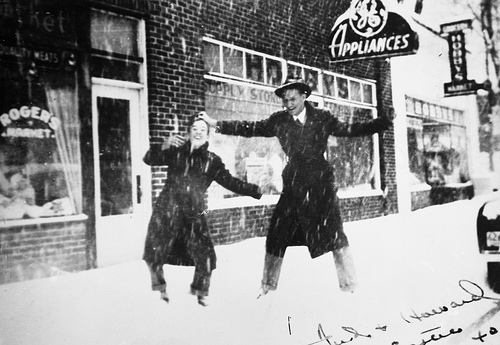 Fred and Howard (last names not known) on corner of Chatham and Academy Streets, in front of Hobby's Appliance Store, Cary, NC, during snow of Easter 1940. From the General Negative Collection, North Carolina State Archives, call # N_2000_4_4. 