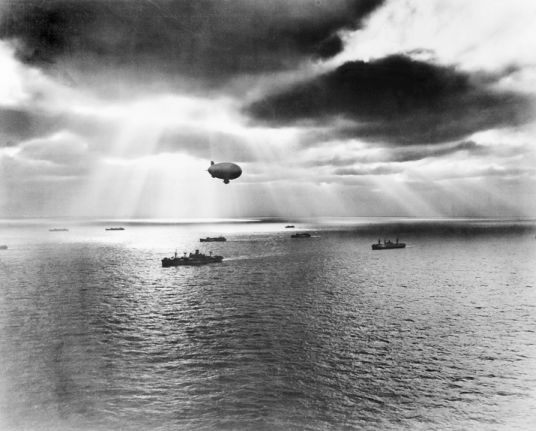 A U.S. Navy blimp protects an Atlantic convoy in 1943. During World War II, Weeksville was a base for blimps that patrolled the Atlantic Ocean off the coasts of North Carolina and Virginia for German submarines. National Archives (neg. 65729, U.S. Navy).